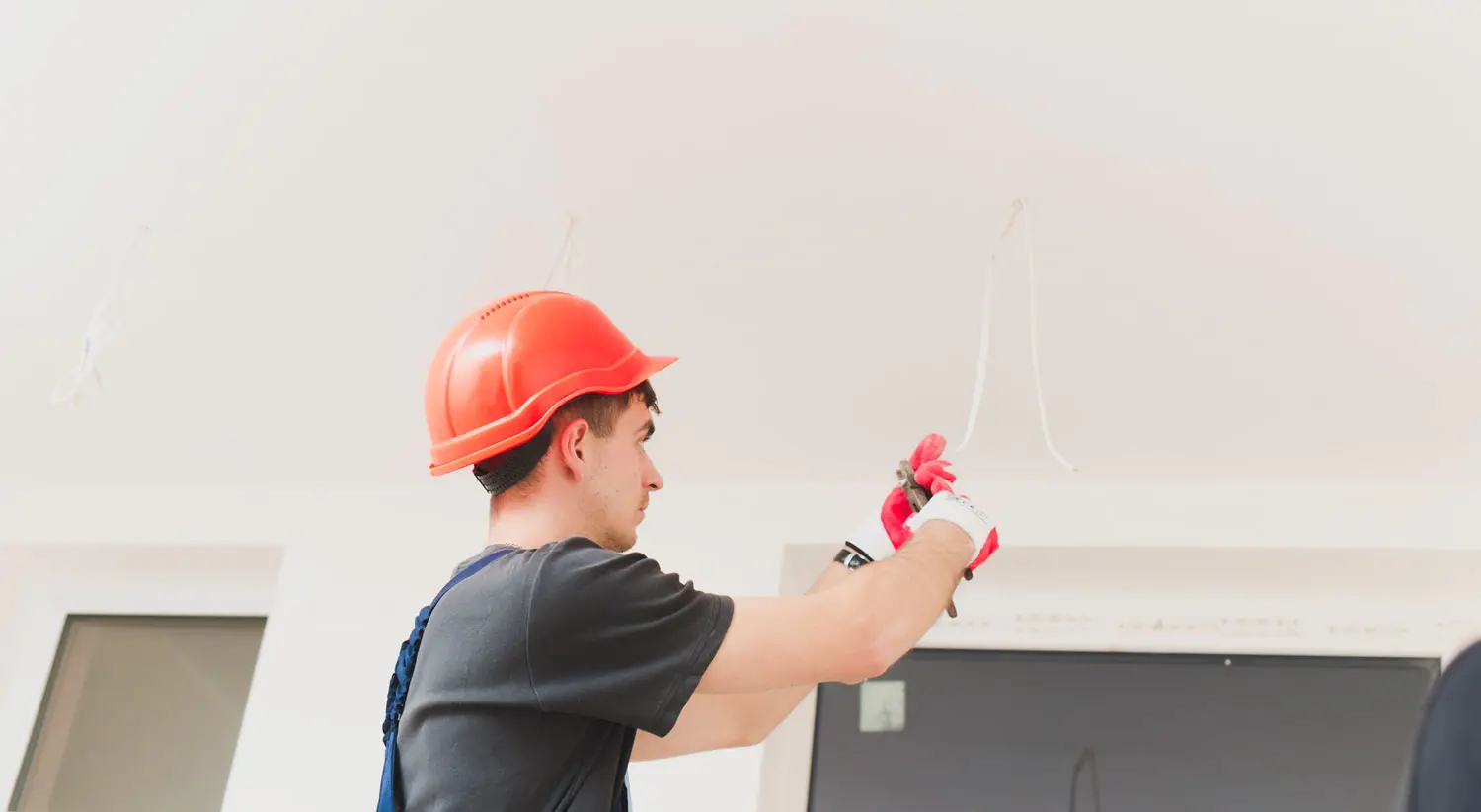 Homem trabalhando com cabos de lumin&aacute;rias